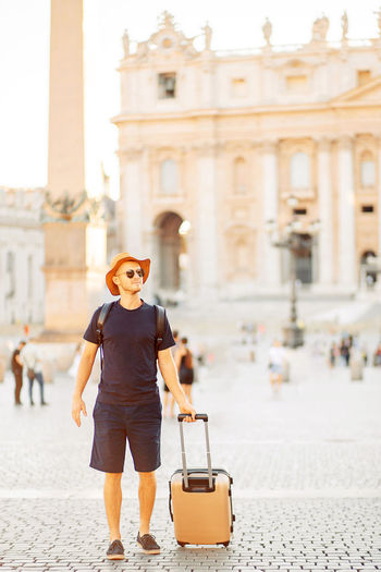 Young man tourist in rome at vatican city on vacation, an emigrant. moving to a new country.