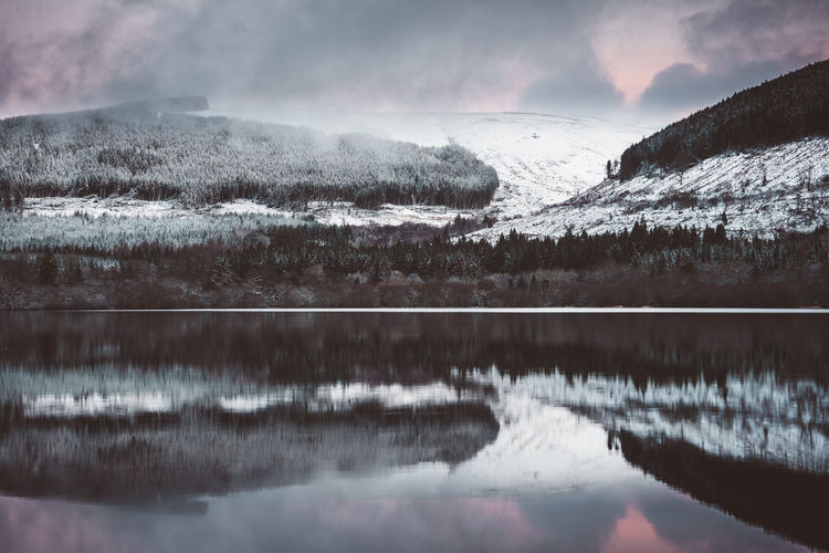 Snowcapped mountain reflecting on calm lake