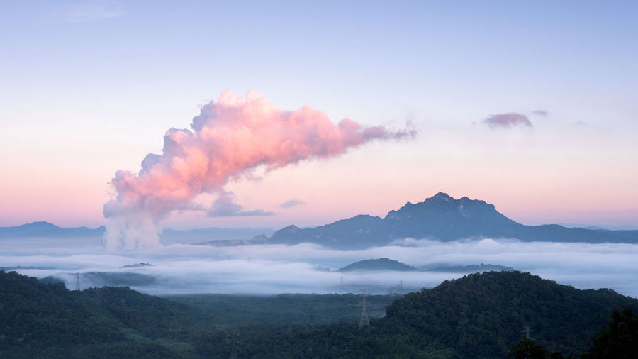 Sea of fog in forest and steam from the coal power plant . mae moh, lampang, thailand