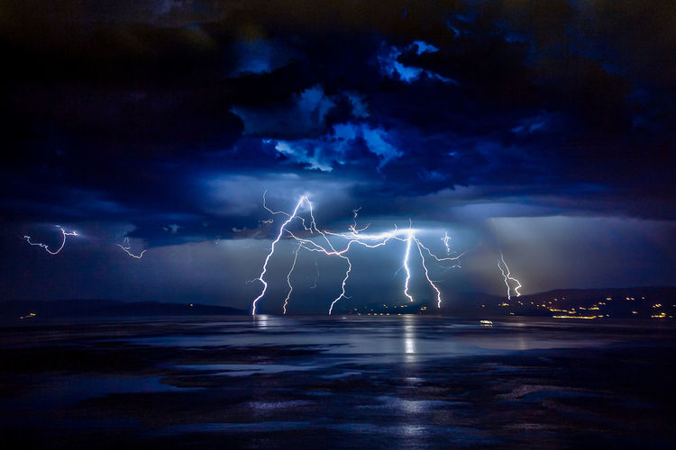 Lightning over sea against storm clouds