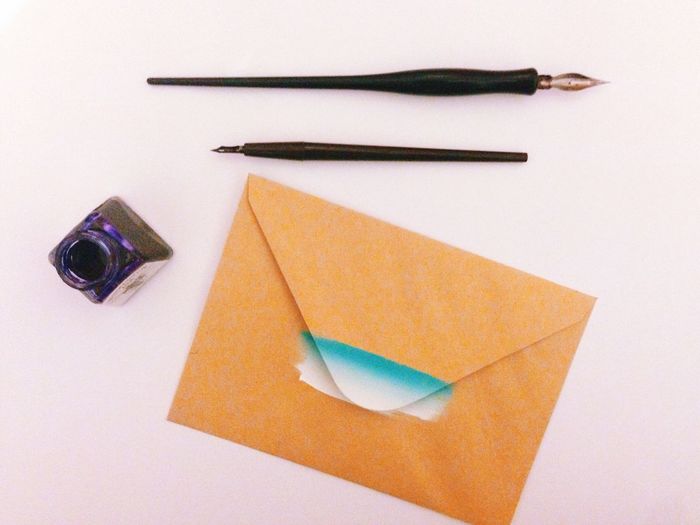 High angle view of envelop with ink well and pen