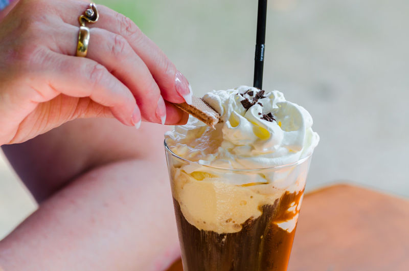 Close-up of female hand with iced coffee