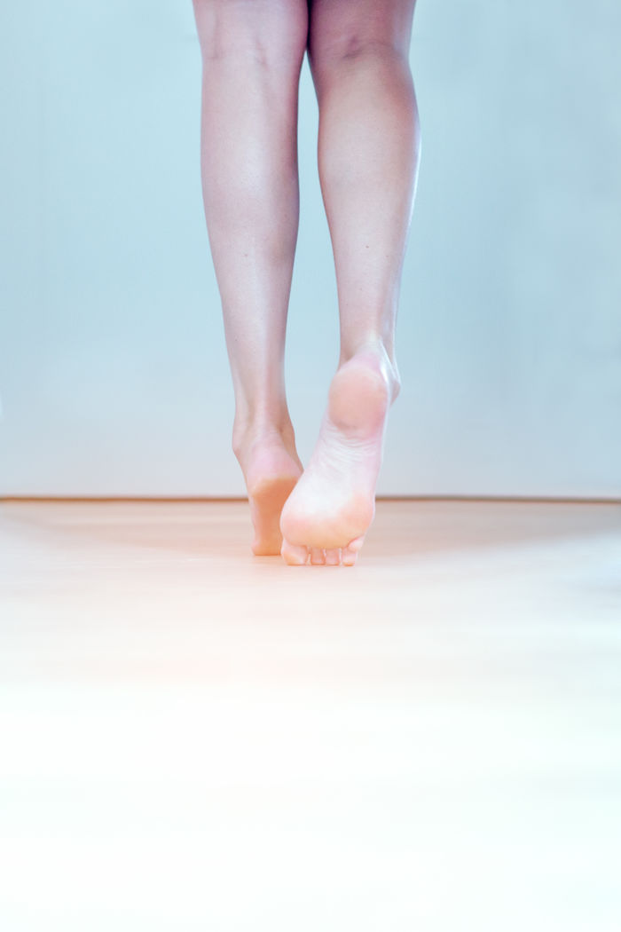 Low section of woman tiptoeing on floor