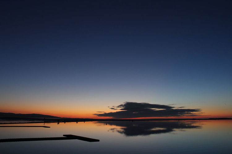 Scenic view of calm lake at dusk