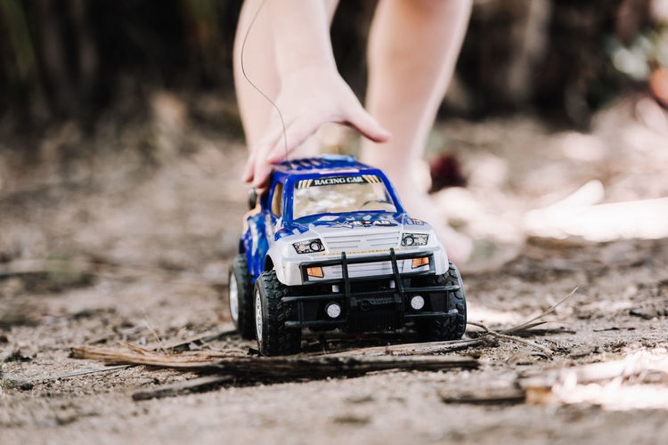 Close-up of child playing with toy car outdoors