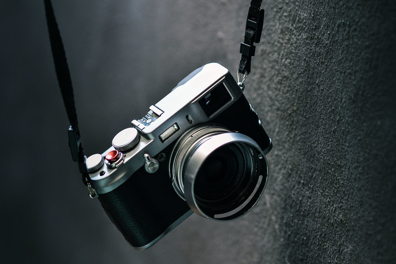 Close-up of camera hanging by wall