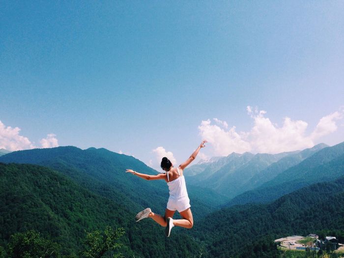 Woman jumping against mountains