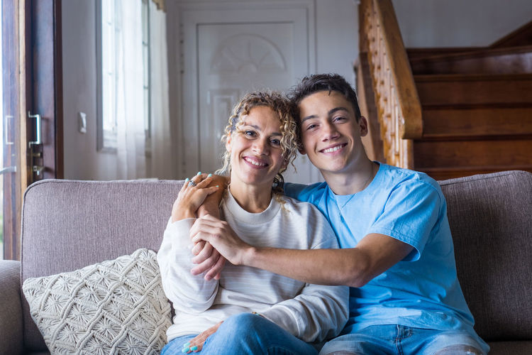 Portrait of smiling family sitting on sofa at home