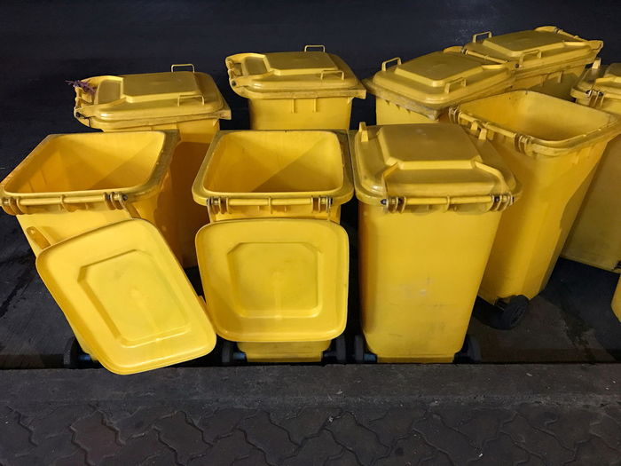 Yellow garbage cans on footpath