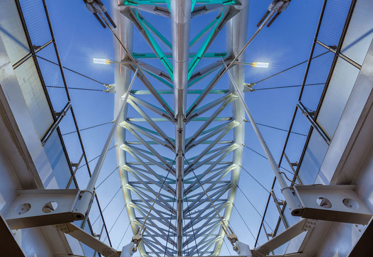 Low angle view of illuminated bridge against sky at dusk