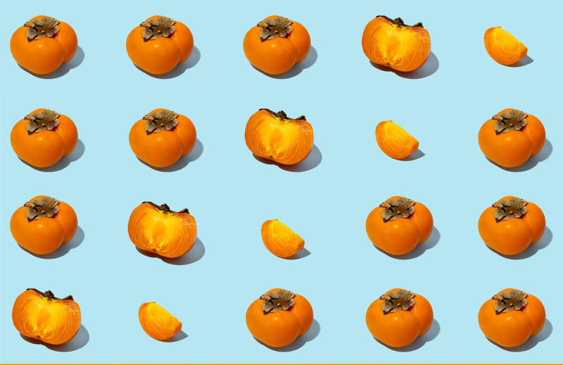 Full frame shot of orange pumpkins against blue background