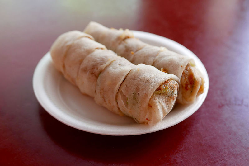 Close-up of fresh popiah served in plate on red table