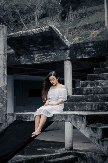 Portrait of a smiling young woman sitting on staircase