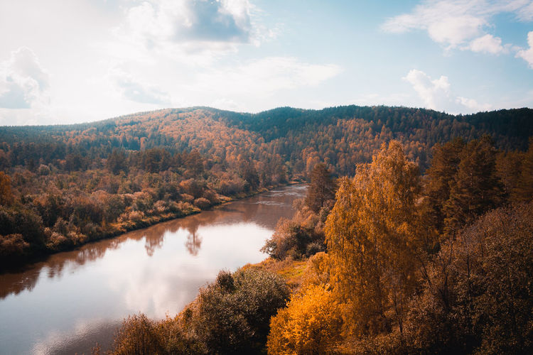 Scenic view of lake in forest against sky during autumn