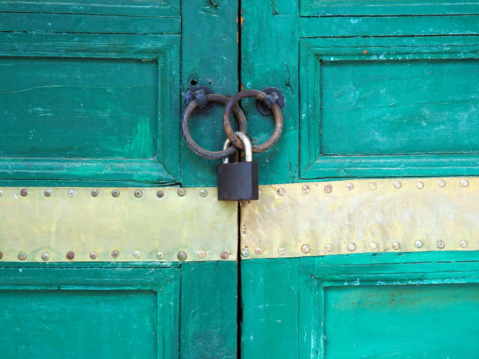 Padlock in rusty rings on door