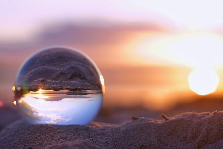 Close-up of illuminated crystal ball against sunset