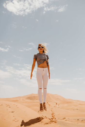 Woman levitating over desert in sunny day