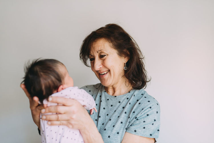 Happy grandmother holding her granddaughter