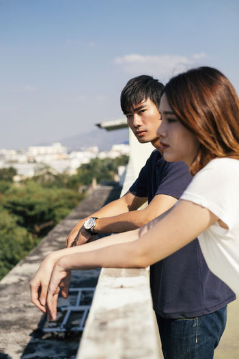 Couple standing on terrace in city during summer