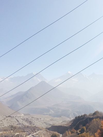 Electricity pylon on mountain against sky