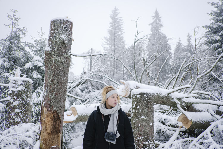 Full length of woman standing on snow covered plants