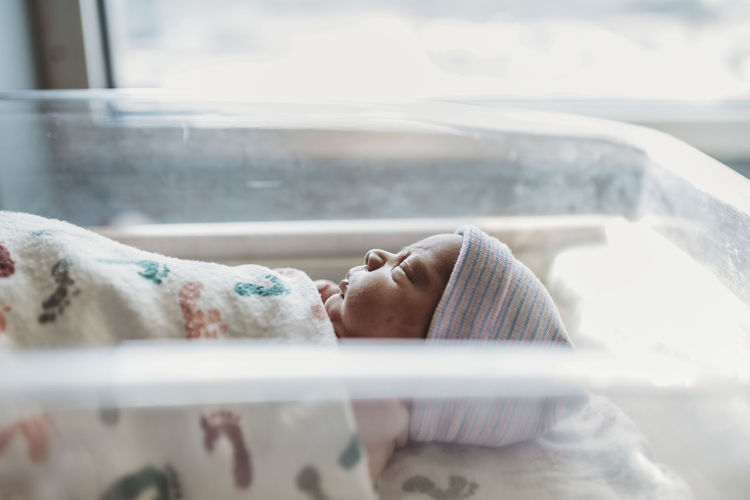 Side view of newborn boy profile with hat in hospital