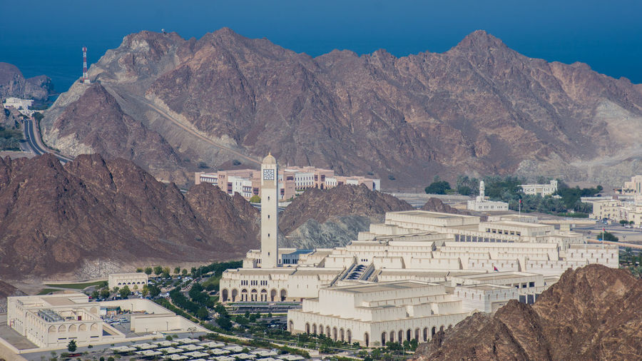 Oman parliament buildings in city against mountain range