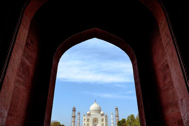 Taj mahal seen from entrance against sky