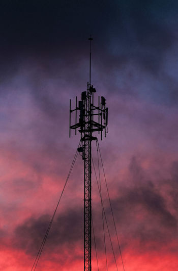 Low angle view of silhouette tower against cloudy sky during sunset