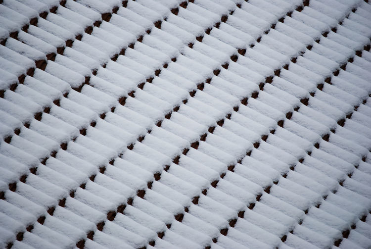 Abstract pattern of snow covered roof tiles