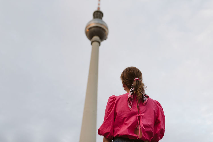 Rear view of woman with tower against sky