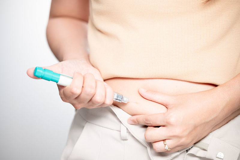 Midsection of woman holding syringe