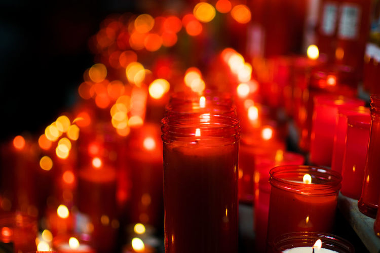 Close-up of red illuminated candles on table
