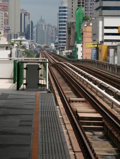 Railroad station platform against buildings in city