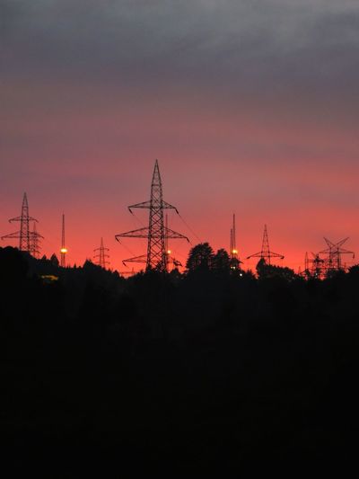 Silhouette of electricity pylon against sky during sunset