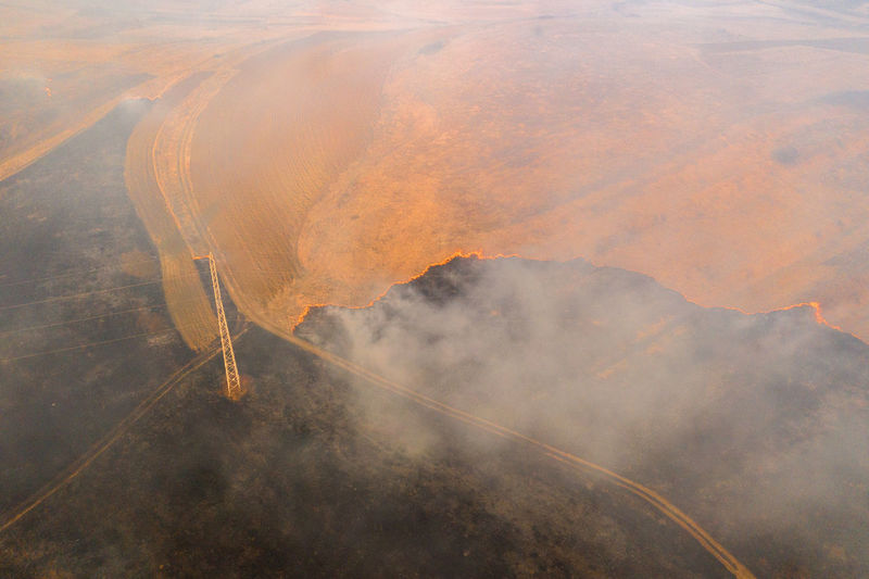 Aerial view of spring dry grass burning field. fire and smoke in the meadow, nature pollution