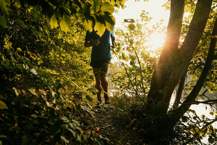 Full length of man running amidst plants