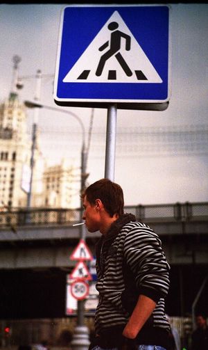 Full length of man standing by sign in city