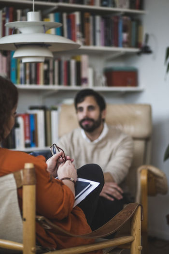 Female therapist with male patient during therapy session at home office