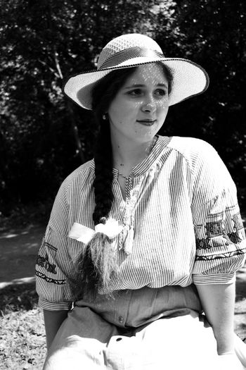 Portrait of woman wearing hat sitting outdoors