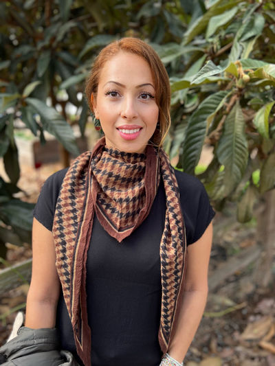 Portrait of young woman standing against plants