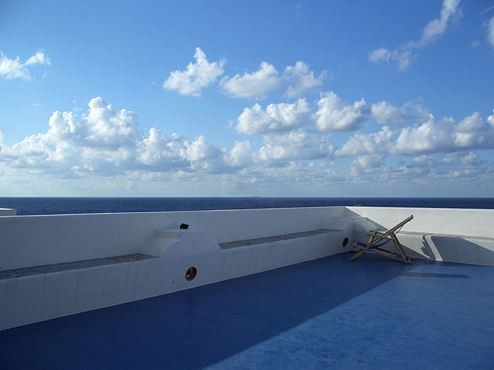 Chair on ship at sea against sky