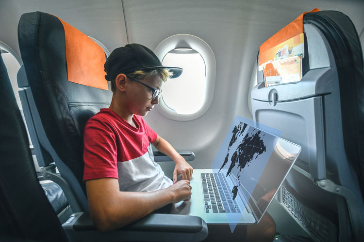Young man using laptop while sitting in car