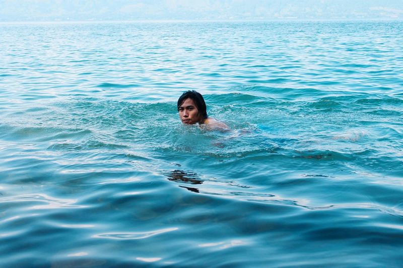 Portrait of young adult swimming in sea