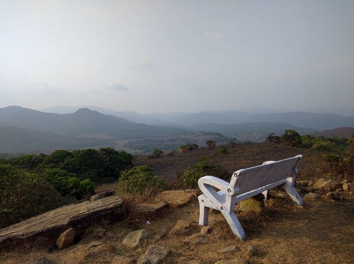 A nice bench in front of the scenic view of the whole coorg valley in india at sunset.
