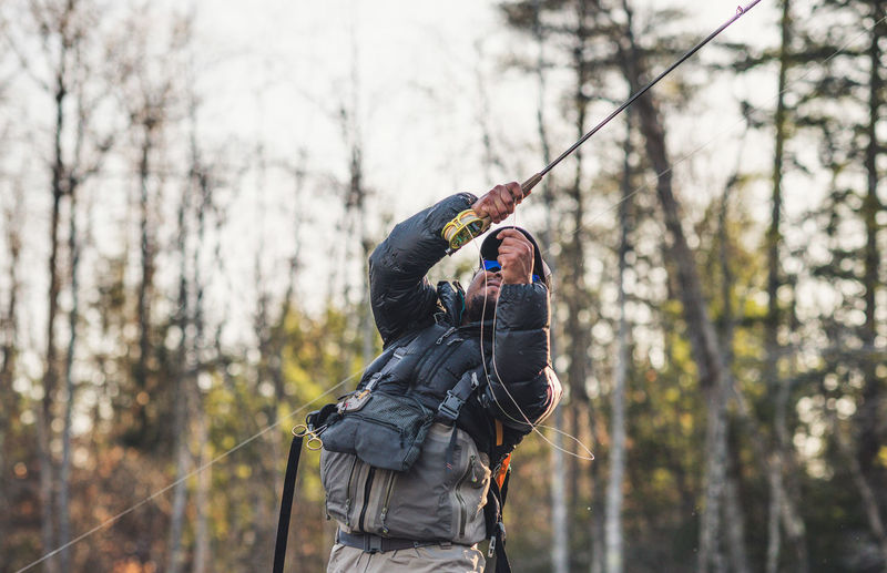 A man sets a hook while fly-fishing in maine