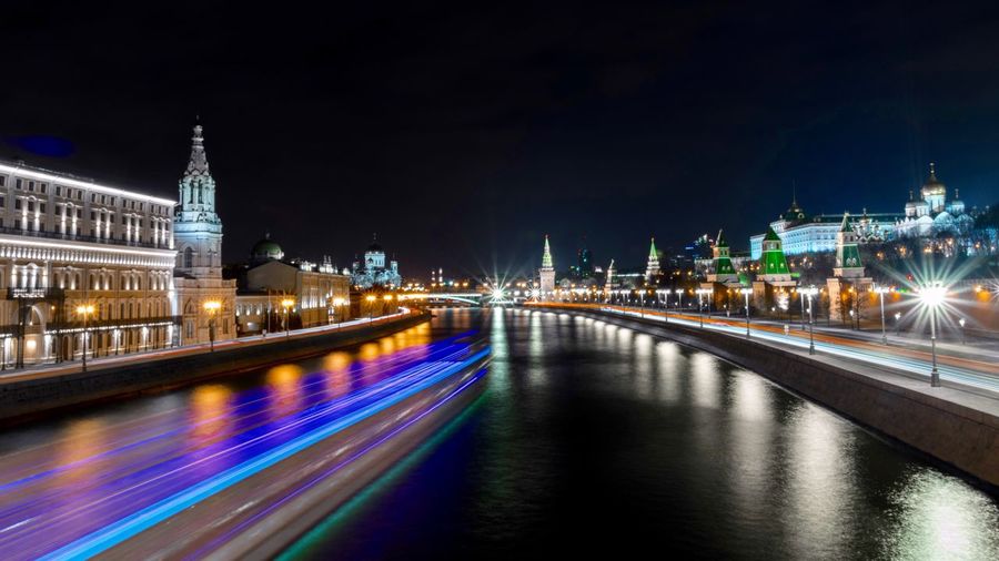 Light trails on bridge over river at night