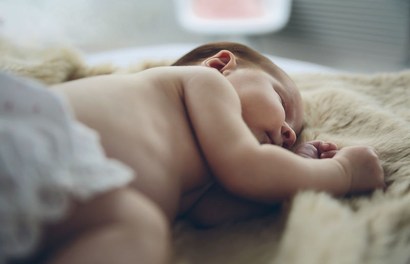 Cute baby girl sleeping on bed