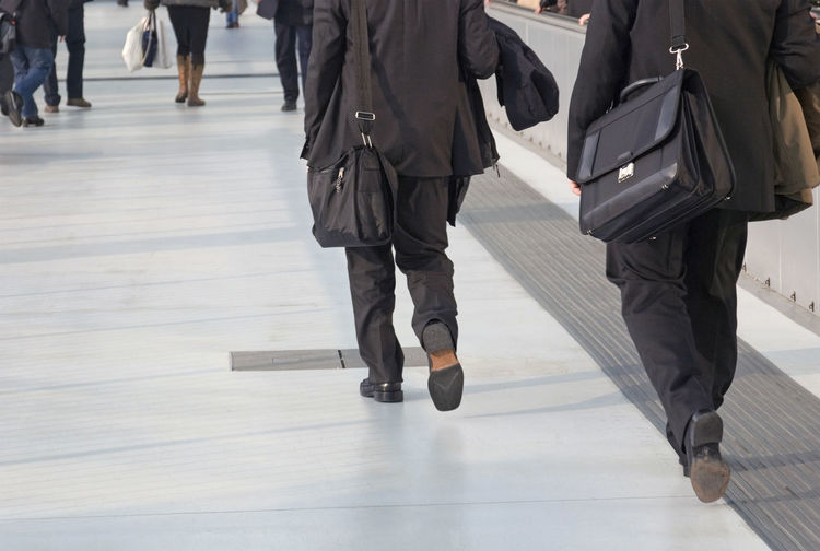 Low section of people walking on floor in city