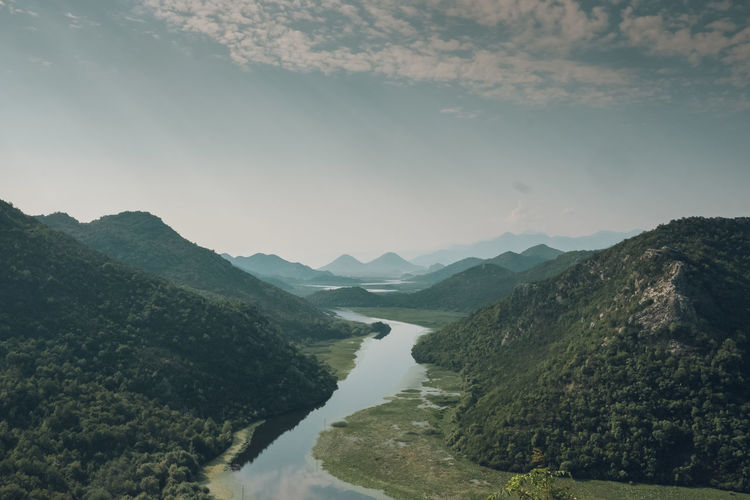 Scenic view of river amidst mountains against sky